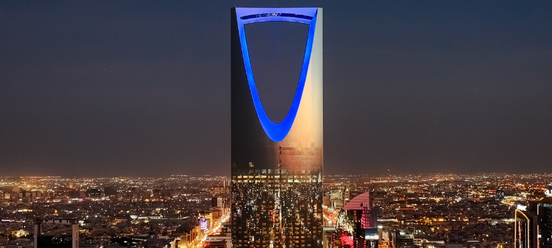 Modern skyscraper illuminated at night in saudi arab property market